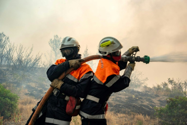Photo prise le 6 août 2025 et diffusée le 7 août 2025 par la Sécurité civile de pompiers luttant contre un incendie de forêt, près de Ribaute et Saint-Laurent-de-la-Cabrerisse, dans l'Aude ( Sécurité civile / Handout )
