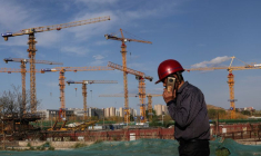 Un ouvrier passe devant un chantier de construction à Pékin