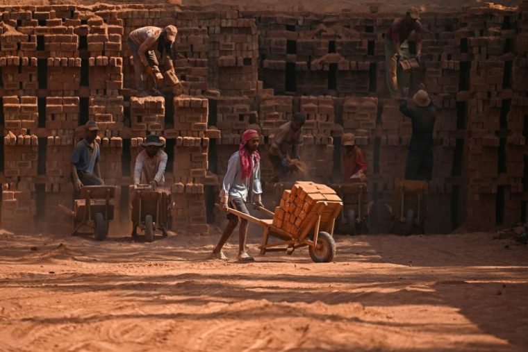 Des travailleurs migrants indiens occupés dans une briqueterie à la périphérie de Srinagar, le 24 août 2026 ( AFP / Tauseef MUSTAFA )