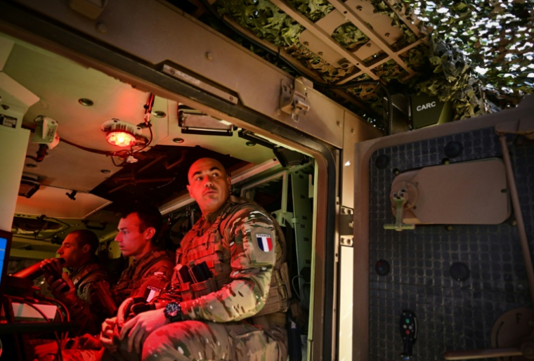 Des militaires français à l'arrière d'un véhicule blindé sur le champ de bataille de Bucium, lors de l'exercice Dacian Fall de l'Otan, le 2 novembre 2025 ( AFP / Daniel MIHAILESCU )