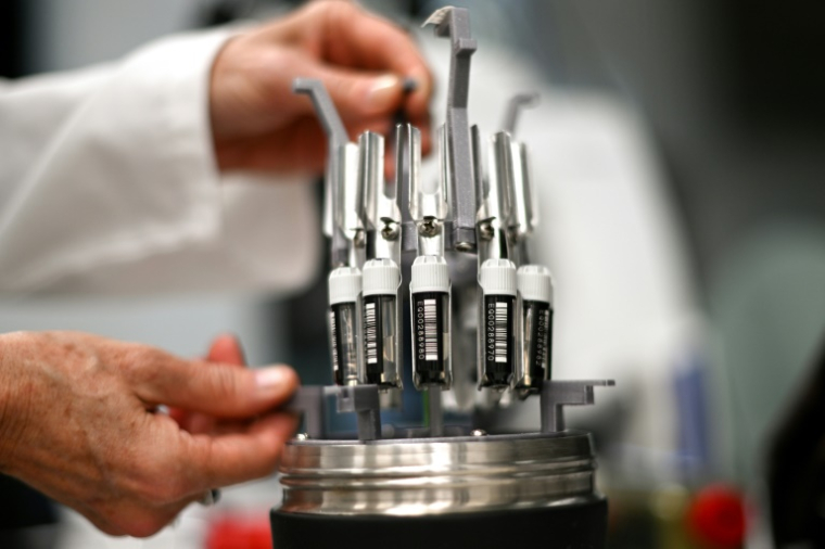 Justine O'Brien, responsable des sciences de la conservation à la Taronga Conservation Society Australia, place des échantillons de gamètes de corail dans un rack cryogénique rempli d'azote liquide dans un laboratoire de Sydney, le 29 mai 2025 en Australie ( AFP / Saeed KHAN )