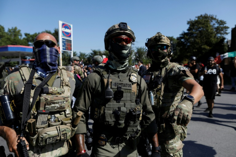 Des agents masqués de la patrouille frontalière des douanes et de la protection des frontières des États-Unis (CBP) derrière cordon de police à Chicago, le 4 octobre 2025 dans l'Ilinois ( AFP / OCTAVIO JONES )