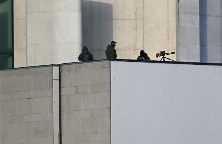 Des tireurs d'élite de la police en position sur un toit aux abords de la chancellerie à Berlin, lors de la visite du président ukrainien Volodymyr Zelensky, le 15 décembre 2025 ( AFP / RALF HIRSCHBERGER )