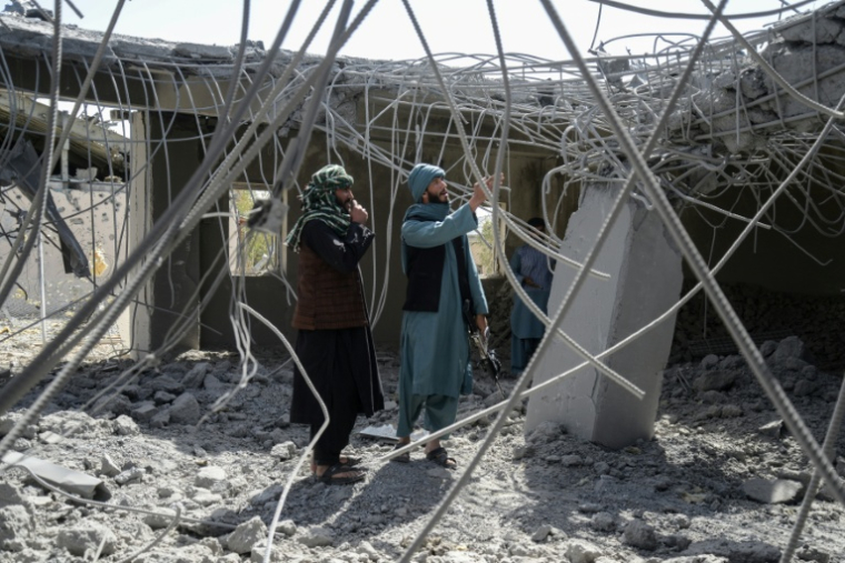 Des membres des forces de sécurité talibanes inspectent un bâtiment endommagé après une frappe pakistanaise dans la région de Kandahar, le 15 mars 2026 ( AFP / - )