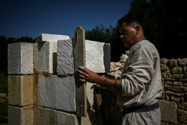 Frédéric Thibault, tailleur de pierre, dirige la construction d'une cathédrale gothique à La Lande-de-Fronsac, en Gironde, le 16 mai 2025 ( AFP / Philippe LOPEZ )