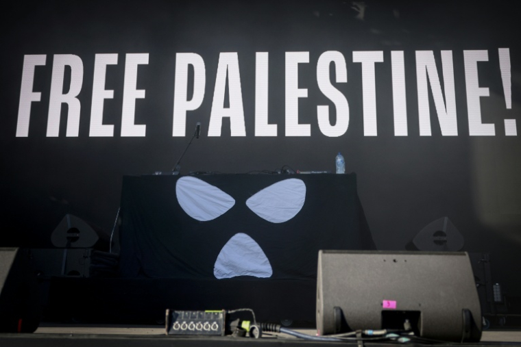 This photograph shows a slogan which reads "Free Palestine!" screened on stage ahead of the start of the set of Northern Ireland hip-hop trio Kneecap, at the Rock en Seine music festival, in Saint-Cloud, near Paris, on August 24, 2025. ( AFP / Guillaume BAPTISTE )