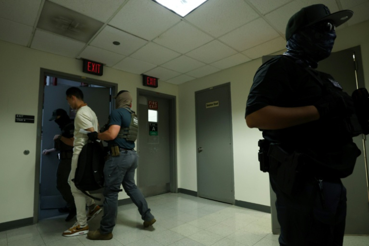 Un homme détenu par des agents fédéraux après une audience dans un tribunal d'immigration situé dans l'immeuble fédéral Jacob K. Javitz de New York, le 17 juillet 2025. ( AFP / CHARLY TRIBALLEAU )