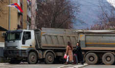 Des habitants marchent près d'un barrage routier dans la partie nord de la ville ethniquement divisée de Mitrovica