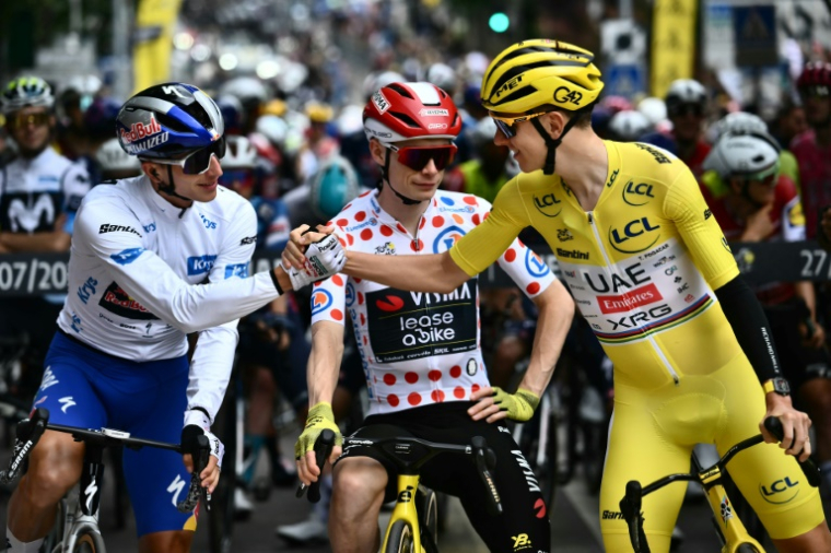 L'Allemand Florian Lipowitz (G) avec Jonas Vingegaard (C) et Tadej Pogacar au départ de la dernière étape du Tour de France, à Mantes-la-Ville, le 27 juillet 2025 ( AFP / Marco BERTORELLO )
