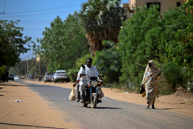 Un bénévole soudanais chargé de livrer des médicaments à domicile roule en moto à Khartoum, le 18 avril 2026 ( AFP / Khaled DESOUKI )