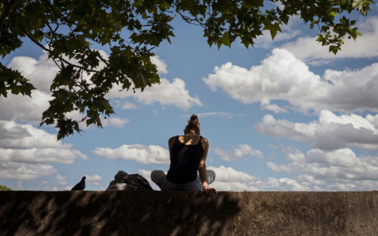 Une femme assise à l'ombre à Toulouse le 11 mai 2026 ( AFP / Ed JONES )
