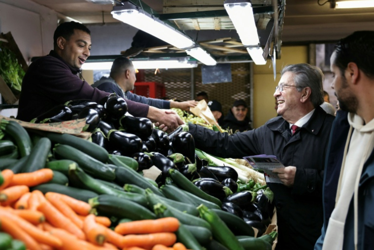 Jean-Luc Mélenchon (c), leader de La France Insoumise (LFI), salue un vendeur lors d'une visite au marché de Choisy-le-Roi, le 2 novembre 2025 dans le Val-de-Marne ( AFP / Thomas SAMSON )