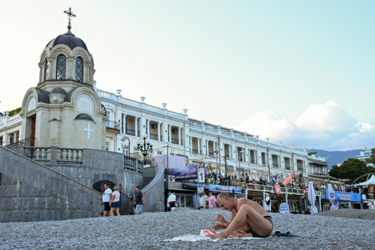 Un estivant joue aux cartes sur une plage de Yalta, en Crimée annexée, le 21 juillet 2026 ( AFP / Igor IVANKO )