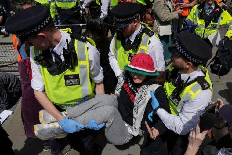 Des des policiers dispersent des manifestants rassemblés devant la Cour royale de justice, alors que la Haute Cour rend son verdict sur l'interdiction du groupe Palestine Action, le 15 juin 2026 à Londres ( AFP / CARLOS JASSO )