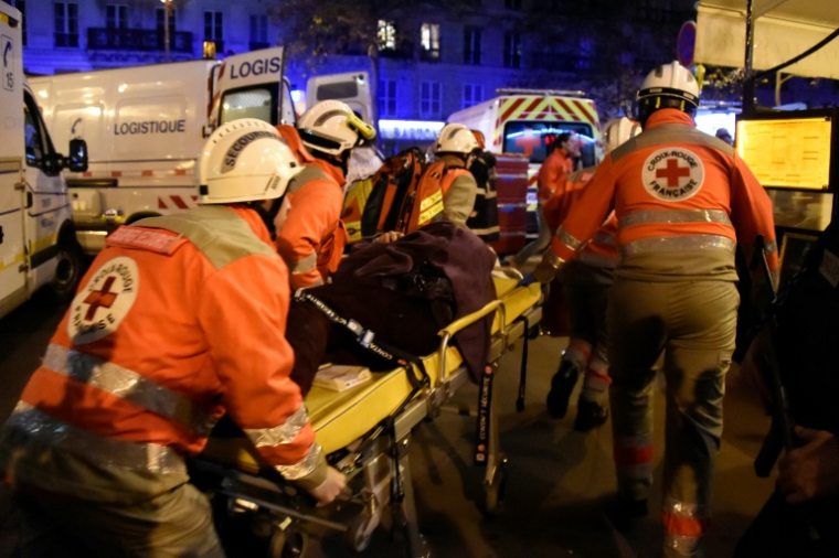 Des membres de la Croix-Rouge française portent secours à des victimes près de la salle de concert du Bataclan à Paris, le 13 novembre 2015 ( AFP / DOMINIQUE FAGET )