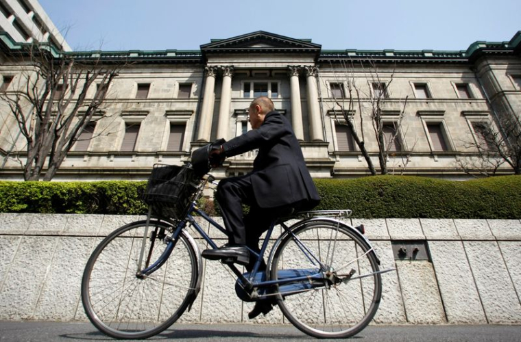 Photo d'archive d'un homme à vélo passant devant le bâtiment de la BOJ à Tokyo