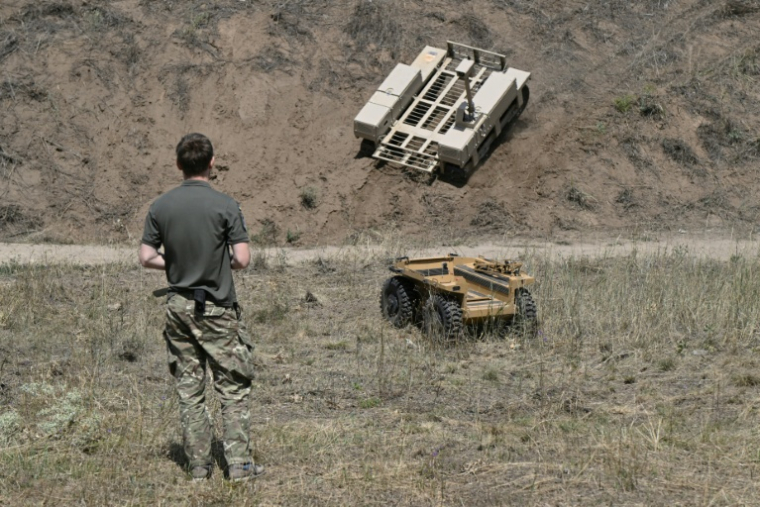 Lors d'un exercice dans un lieu non précisé de l'est de l'Ukraine le 13 août 2025, un soldat ukrainien contrôle des robots dont certains permettent l'évacuation de blessés du front ( AFP / Genya SAVILOV )