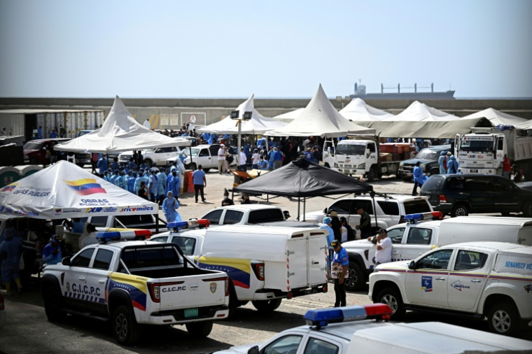 Des experts médicolégaux procèdent à l'identification de corps étendus au sol dans une morgue de fortune située dans le port de La Guaira, au Venezuela, le 29 juin 2026 ( AFP / Federico PARRA )
