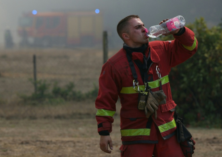 Un sapeur-pompier, qui combat le feu de forêt à Lanton, se désaltère, le 29 juillet 2026 ( AFP / Alain JOCARD )