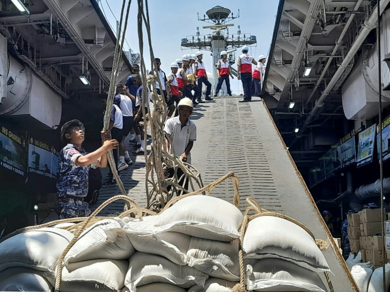 Photo diffusée par le ministère indien des Affaires extérieures, le 5 avril 2025, montrant le déchargement au port de Thilawa de cartons d'aide alimentaire offerts par l'Inde à la Birmanie, frappée par un tremblement de terre le 28 mars ( Mministère indien des Affaires extérieures / - )