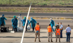 Des passagers espagnols en combinaison de protection, évacués du navire touché par un foyer d'hantavirus, attendent de monter à bord d'un avion à l'aéroport de Tenerife, le 10 mai 2026 ( AFP / Antonio Sempere )