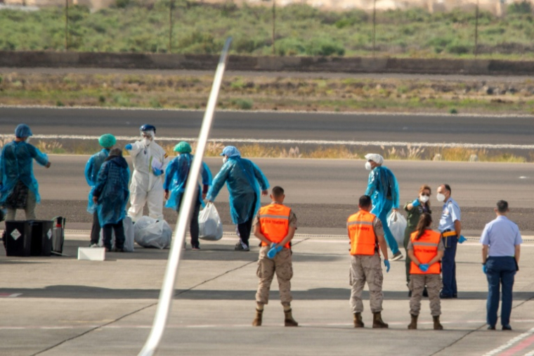 Des passagers espagnols en combinaison de protection, évacués du navire touché par un foyer d'hantavirus, attendent de monter à bord d'un avion à l'aéroport de Tenerife, le 10 mai 2026 ( AFP / Antonio Sempere )