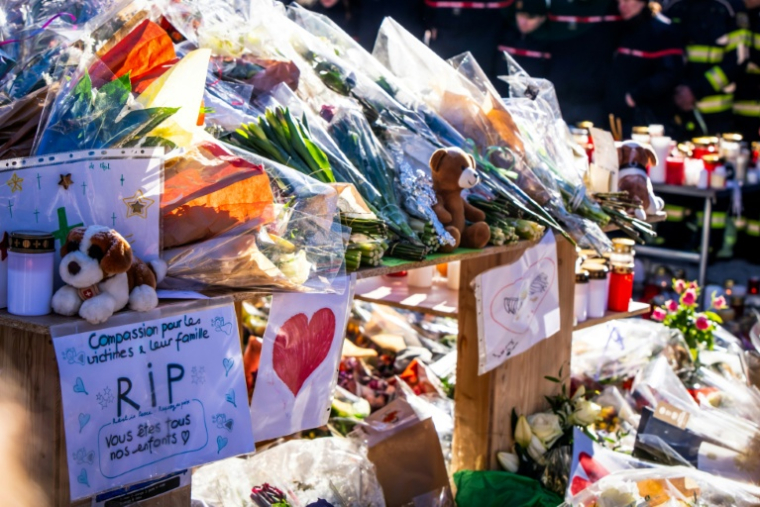 Photo le 4 janvier 2026 de fleurs et messages en hommage aux victimes de l'incendie d'un bar à Crans-Montana, en Suisse ( AFP / MAXIME SCHMID )