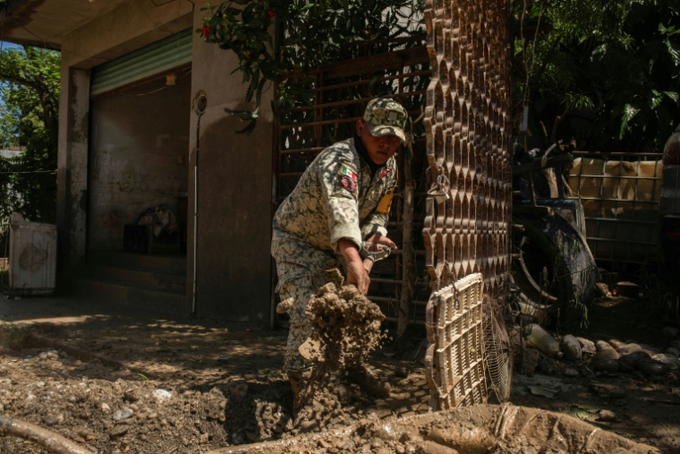 Un soldat mexicain enlève la boue à l'intérieur d'une maison inondée à Alamo, dans l'Etat de Veracruz, le 12 octobre 2025 ( AFP / Hector Quintanar  )