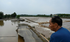 Une route endommagée est visible dans une zone inondée après de fortes pluies dans le village de Taishitun, dans le district de Miyun, à la périphérie de Pékin, le 28 juillet 2025 ( AFP / Jade GAO )
