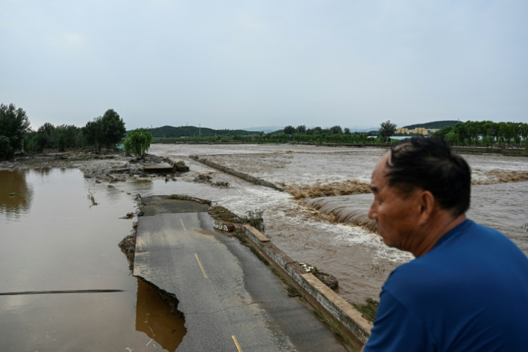 Une route endommagée est visible dans une zone inondée après de fortes pluies dans le village de Taishitun, dans le district de Miyun, à la périphérie de Pékin, le 28 juillet 2025 ( AFP / Jade GAO )