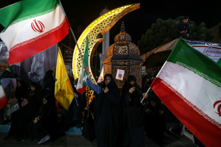 Des partisans de l'ayatollah Mojtaba Khamenei brandissent des drapeaux iraniens lors d'un rassemblement à Téhéran, le 27 avril 2026 ( AFP / ATTA KENARE )