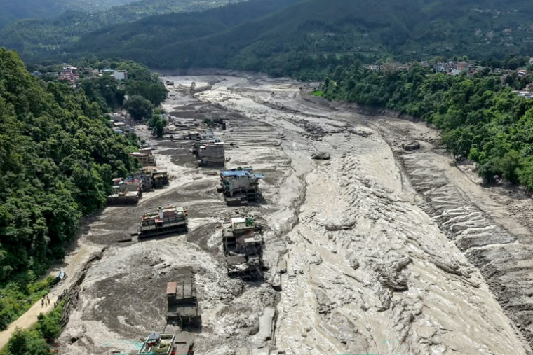 Des maisons sont partiellement submergées par une eau boueuse le long d'une rivière après des crues soudaines à Trishuli Bazar, dans le district de Nuwakot, au Népal, le 26 août 2026. ( AFP / Prabin RANABHAT )