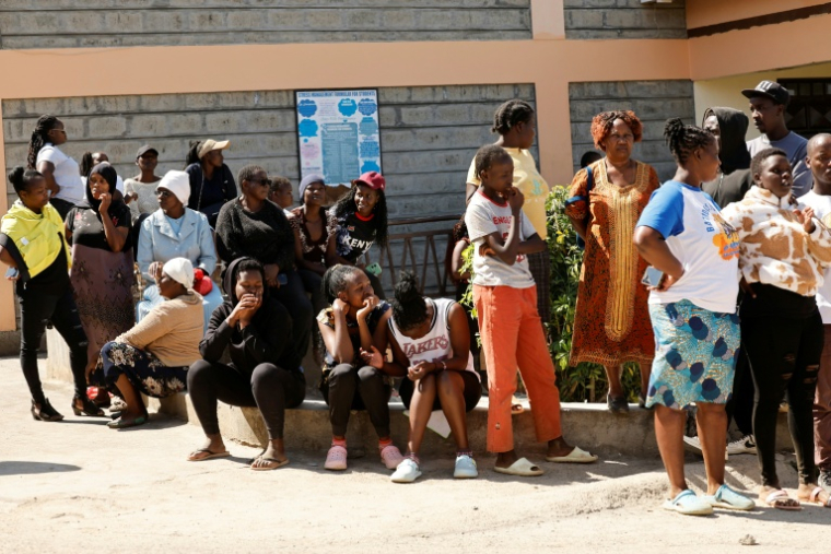 Des proches attendent le 28 mai 2026 dans la cour des nouvelles de pensionnaires de l'école de filles de Gilgil, au Kenya, dont un dortoir a été ravagé dans la nuit par un incendie qui a tué 16 élèves et en a blessé 79 ( AFP / SIMON MAINA )