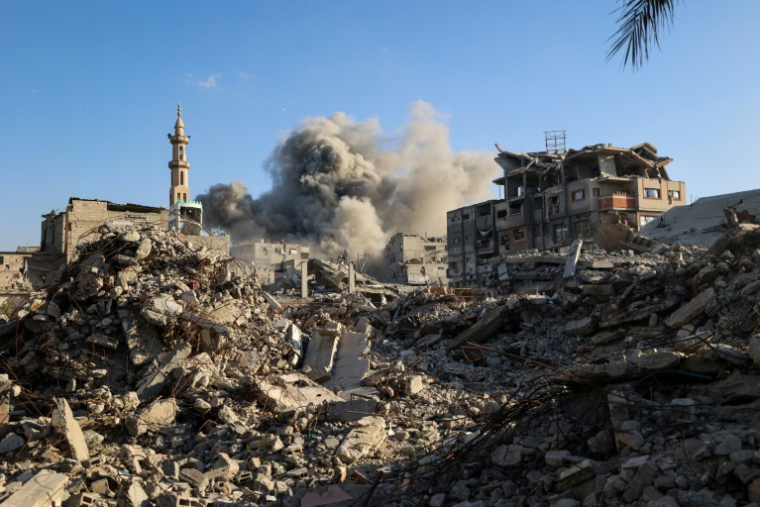 Un nuage de fumée s'élève après une frappe israélienne qui a visé un bâtiment dans le camp de réfugiés palestiniens de Bureij, dans le centre de la bande de Gaza, le 19 octobre 2025 ( AFP / Eyad BABA )