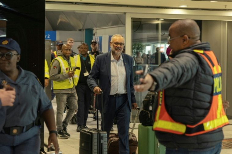 L'ancien ambassadeur d'Afrique du Sud aux États-Unis, Ebrahim Rasool (c), arrive à l'aéroport international du Cap, après son expulsion des Etats-Unis, le 23 mars 2025 en Afrique du Sud ( AFP / GIANLUIGI GUERCIA )