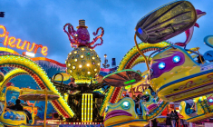 (Crédits photo : Adobe Stock - Manèges d'une fête foraine pour les familles à la tombée de la nuit)