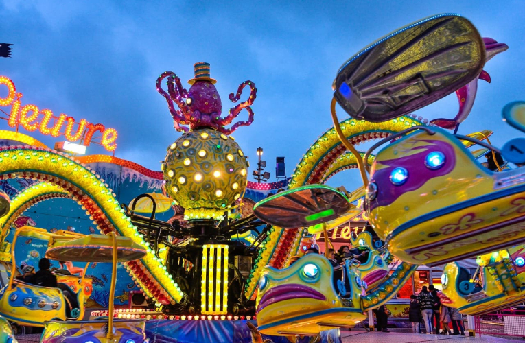(Crédits photo : Adobe Stock - Manèges d'une fête foraine pour les familles à la tombée de la nuit)
