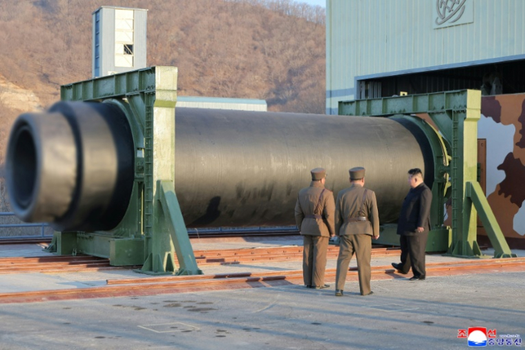 Photo non datée, diffusée par l'agence de presse officielle nord-coréenne Kcna, le 29 mars 2026, du dirigeant nord-coréen Kim Jong Un (d) assistant au test d'un moteur de missile à combustible solide, dans un lieu non divulgué en Corée du Nord ( KCNA VIA KNS / STR )