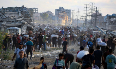 Des Palestiniens marchent le long d'une route de retour d'un point de distribution d'aide de la Fondation humanitaire de Gaza (GHF,) près du camp de réfugiés de Nousseirat, dans le centre de la bande de Gaza, le 25 juin 2025 ( AFP / Eyad BABA )