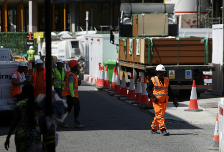 Des ouvriers du bâtiment se regroupent à l'ombre sur un chantier du centre de Londres, le 24 juin 2026 ( AFP / Toby Shepheard )