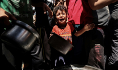 Un enfant pleure au milieu de Palestiniens qui attendent de recevoir un repas chaud distribué par une association caritative locale à Nousseirat, dans le centre de la bande de Gaza, le 24 mai 2025 ( AFP / Eyad BABA )
