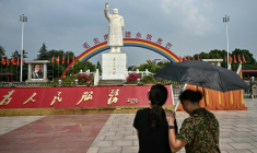 Deux femmes devant la statue de Mao Zedong sur la plage "l'Orient est rouge" de Nanjie, en Chine, le 20 août 2026 ( AFP / Pedro PARDO )
