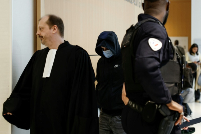 Un animateur (c) d'une école parisienne, poursuivi pour agressions sexuelles sur mineurs, arrive au tribunal de Paris, le 5 mai 2026 ( AFP / Kenzo TRIBOUILLARD )