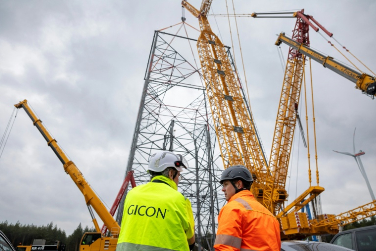 Jochen Grossmann, à gauche, PDG du groupe GICON, et le chef de projet Frank Adam, à sa droite, devant le chantier de la plus haute éolienne du monde à Schipkau, en Allemagne, le 13 mai 2026 ( AFP / Odd ANDERSEN )