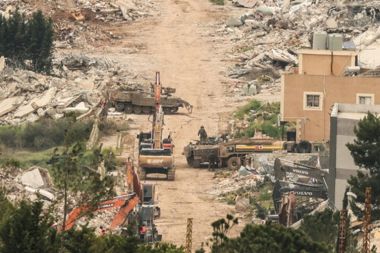 Photo prise du côté israélien de la frontière avec le Liban montrant des véhicules blindés et des excavatrices de l'armée israélienne sur une route longeant des bâtiments détruits dans le sud du Liban, le 15 avril 2026 ( AFP / Jack GUEZ )