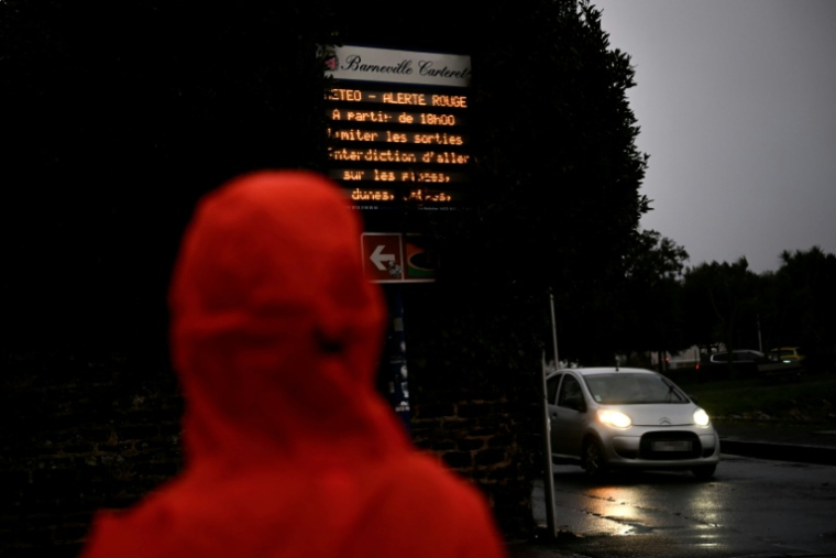 Un piéton se tient devant un panneau d'information, à Barneville-Carteret, près de La Hague, dans le nord-ouest de la France, le 8 janvier 2026 ( AFP / Lou BENOIST )