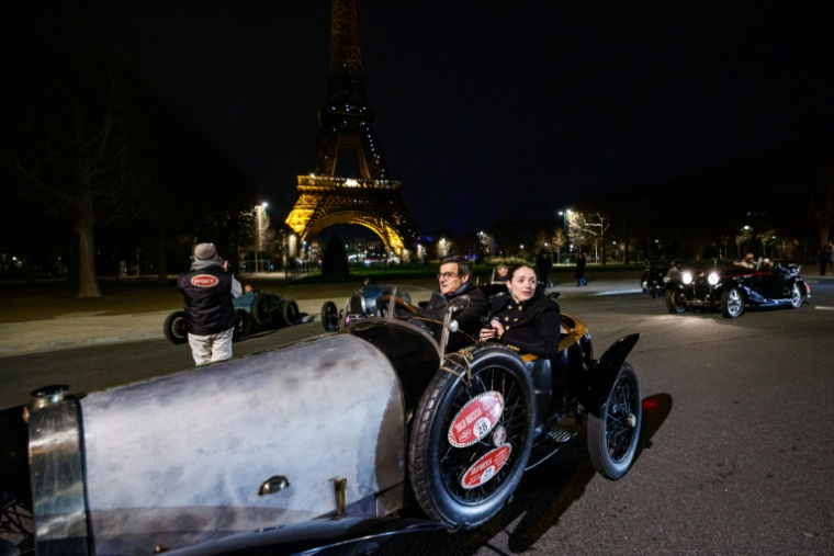 Une voiture de collection Bugatti sur le champ de Mars, devant la tour Eiffel, durant la parade nocturne pour les 50 ans de Rétromobile, le 26 janvier 2026, à Paris ( AFP / Dimitar DILKOFF )