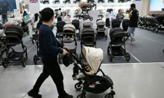 Un homme avec sa poussette dans une allée d'un salon de l'enfant, le 30 avril 2026 à Séoul  ( AFP / Jung Yeon-je )