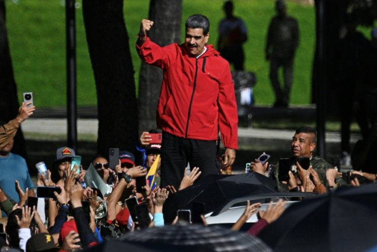 Le président vénézuélien Nicolas Maduro salue ses partisans lors d'une marche organisée pour la Journée de la résistance indigène, à Caracas, le 12 octobre 2025 ( AFP / Federico PARRA )