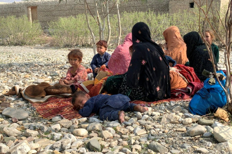 Des rapatriés afghans sont assis dans un champ après avoir échappé à un bombardement nocturne pakistanais près du poste-frontière de Torkham, dans la province de Nangarhar, Afghanistan,le 27 février 2026 ( AFP / Aimal ZAHIR )